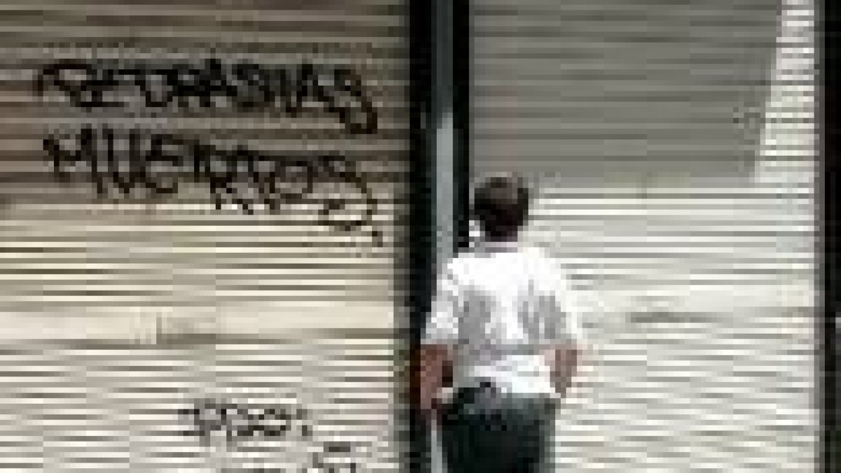Un chico observa la pintada en el local de informática de Murcia