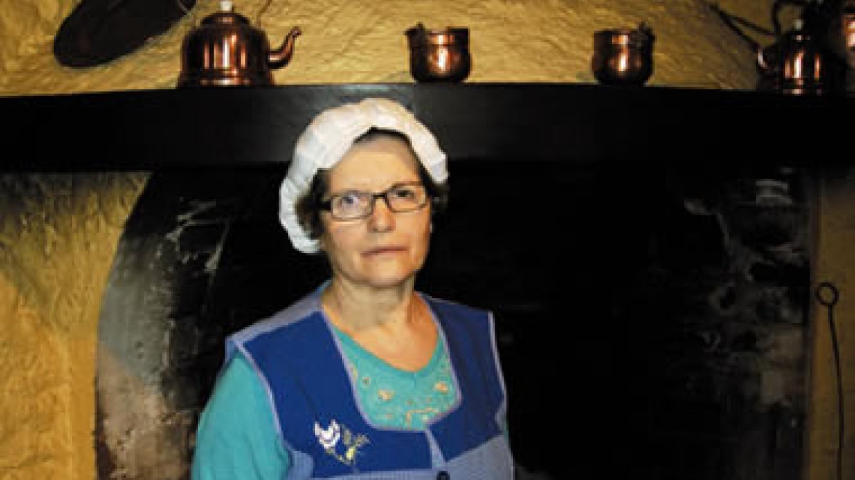 Maruja, la cocinera, el comedor y la fachada del mesón El Apóstol en Cacabelos.