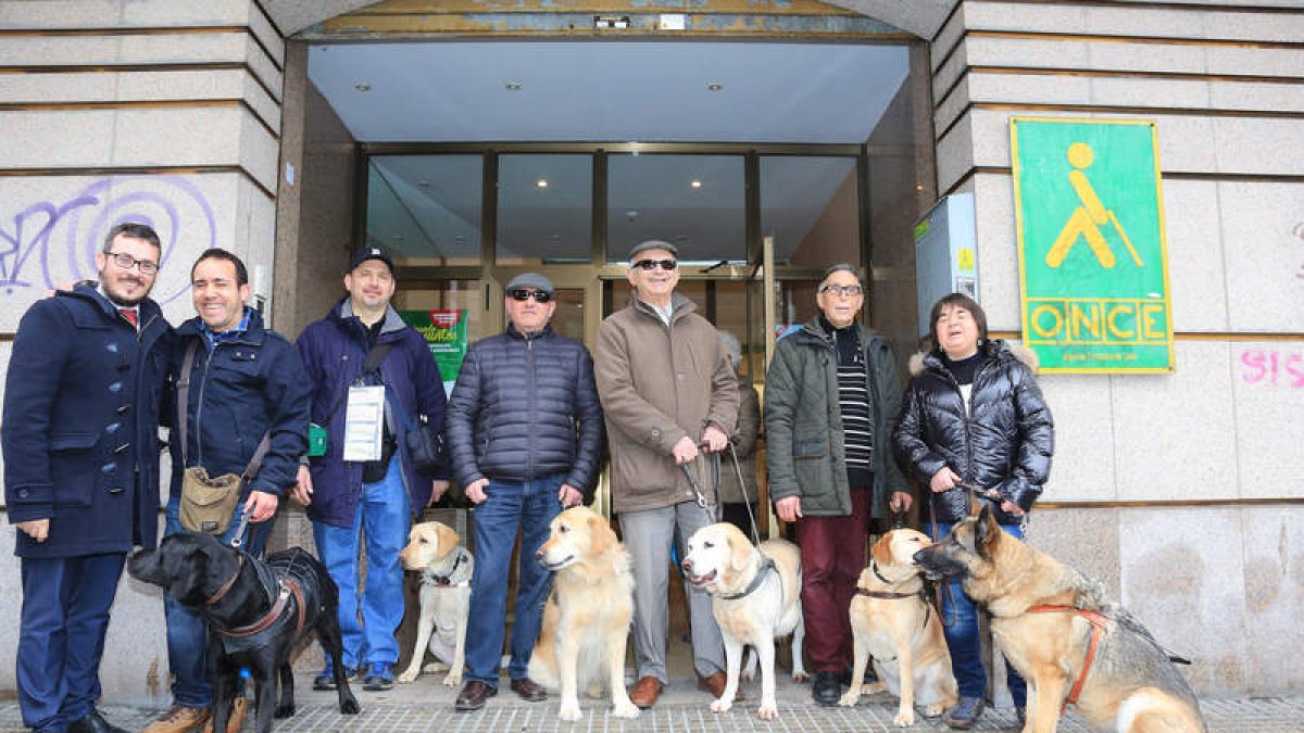 Los perros guía con sus dueños de León y el director de la Once, Óscar Pérez (izquierda) en la puerta de la delegación de León. secundino pérez