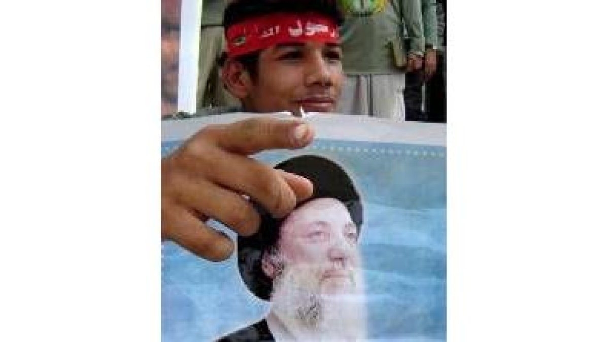 Un niño sostiene un retrato del líder espiritual chií Al Hakim