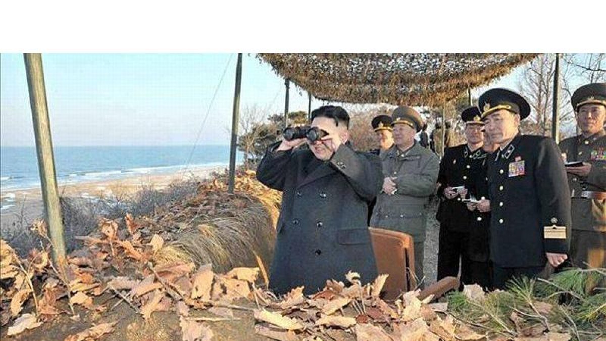 Kim Jong-un observa con unos prismáticos unas maniobras militares en la costa este de Corea del Norte, este lunes.