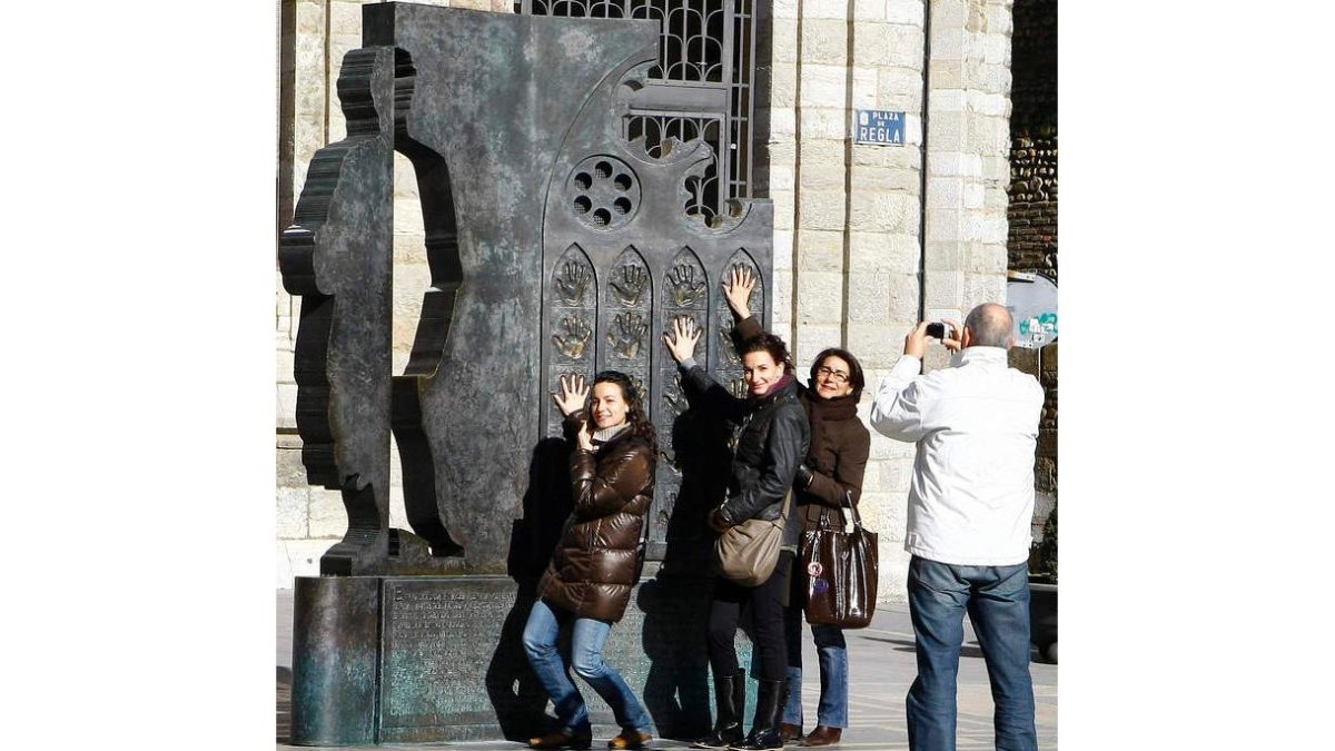 Unos turistas en el monumento de la Plaza de la Catedral.