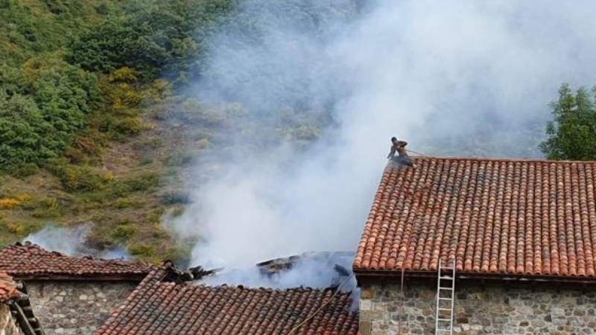 Un vecino trata de sofocar el incendio. DL