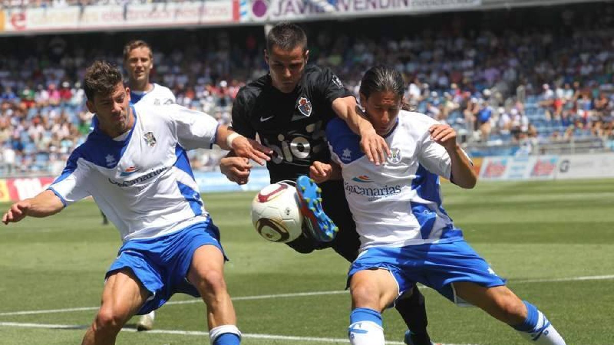 Acorán trata de hacerse con la posesión del balón ante dos jugadores rivales.
