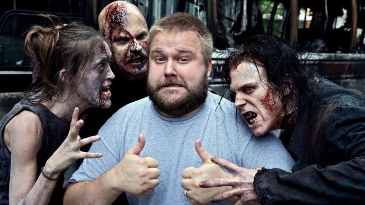 Robert Kirkman, rodeado de algunas de las criaturas protagonistas de The walking dead.