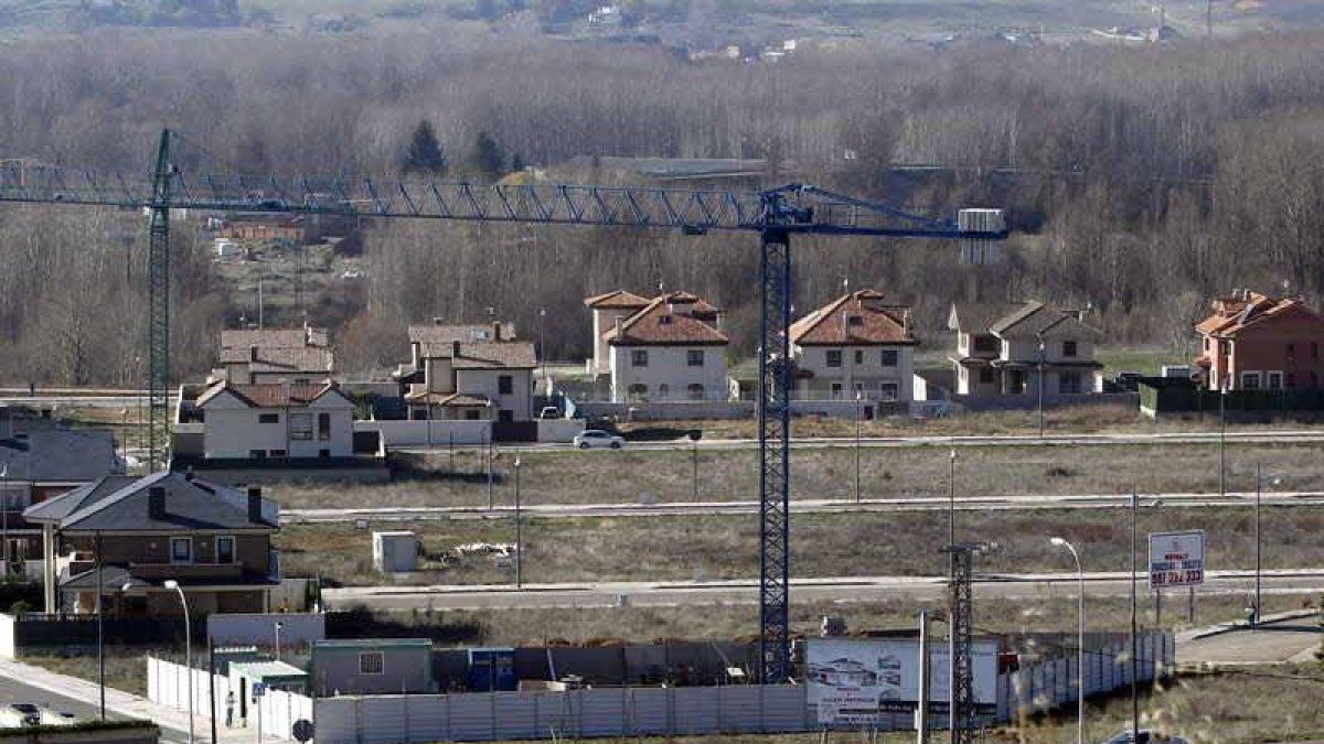 Vista del chalé que se construye Zapatero en Eras de Renueva, en primer término con la grúa.