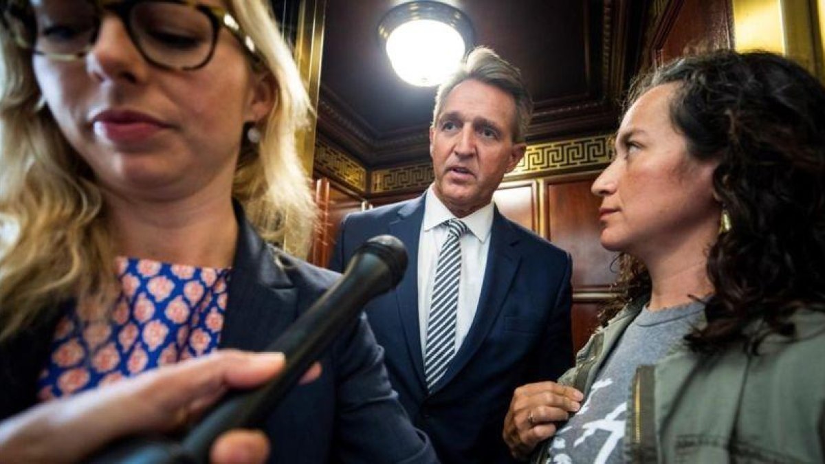 Una presunta víctima de violación, a la derecha, increpa al senador Jeff Flake.Una presunta víctima de violación, a la derecha, increpa al senador Jeff Flake.