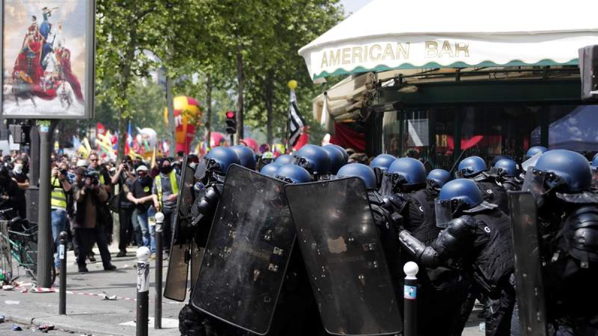 La policía antidisturbios se protege del lanzamiento de proyectiles en una calle de París. IAN LANGSDON