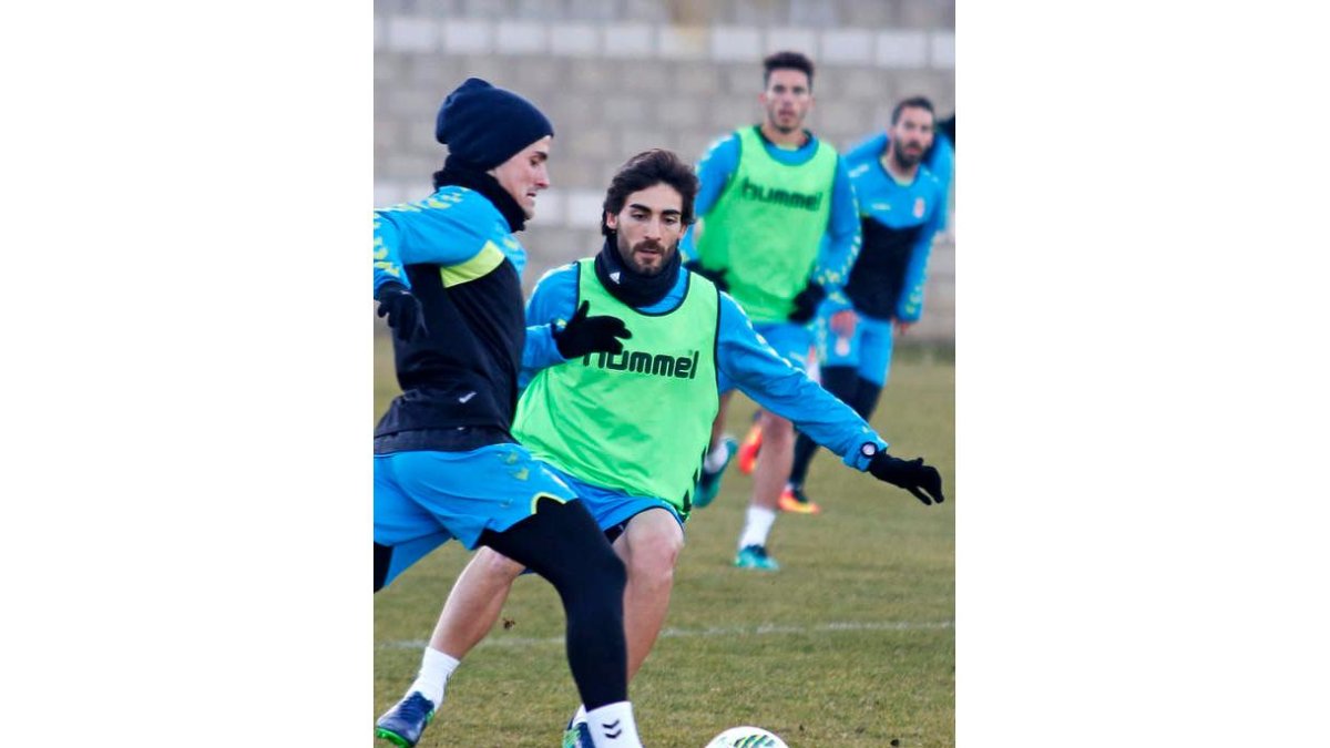 José León, de frente, trata de hacerse con el balón durante un entrenamiento. F. OTERO PERANDONES