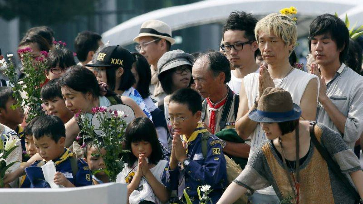 Un grupo de japoneses reza en el cenotafio para las víctimas de la bomba atómica en el Parque Monumento de Paz en Hiroshima.