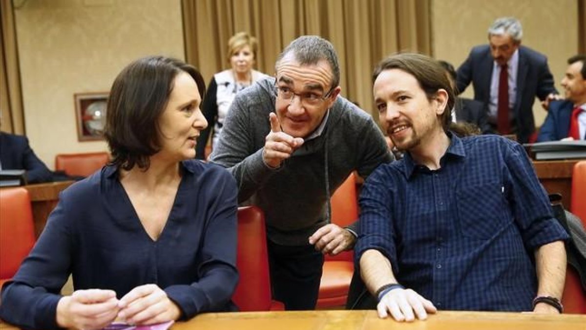 El lider de Podemos, Pablo Iglesias, junto a la reponsable de Analisis del partido, Carolina Bescansa, y el diputado de la formación por Baleares, Juan Pedro Yllanes (en el centro), durante la sesión constitutiva de la Comisión Constitucional en el Congr