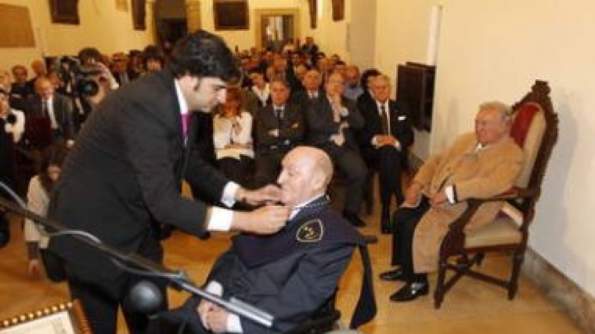 Estapé recibe su condecoración, observado por David Álvarez en presencia de las autoridades.