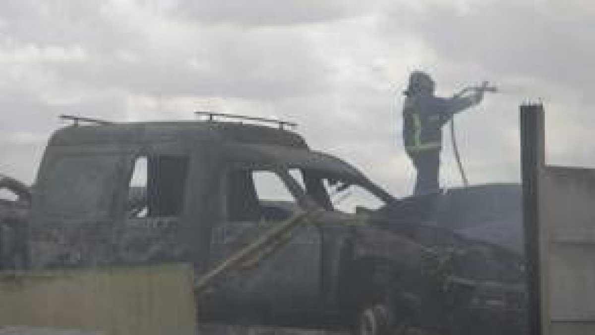 Un efectivo del cuerpo de Bomberos de León trata de apagar el fuego que se produjo en el desguace