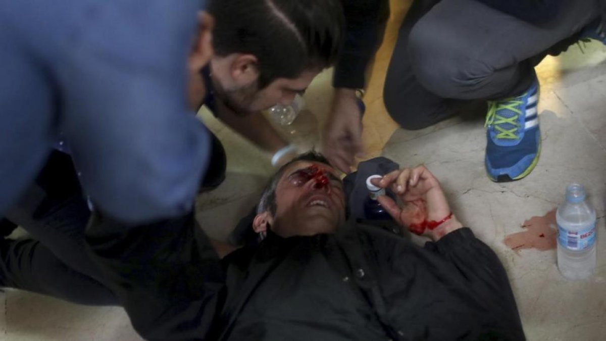 Un manifestante es atendido después de ser golpeado por una bala de goma disparada en la escuela Ramón Llull.