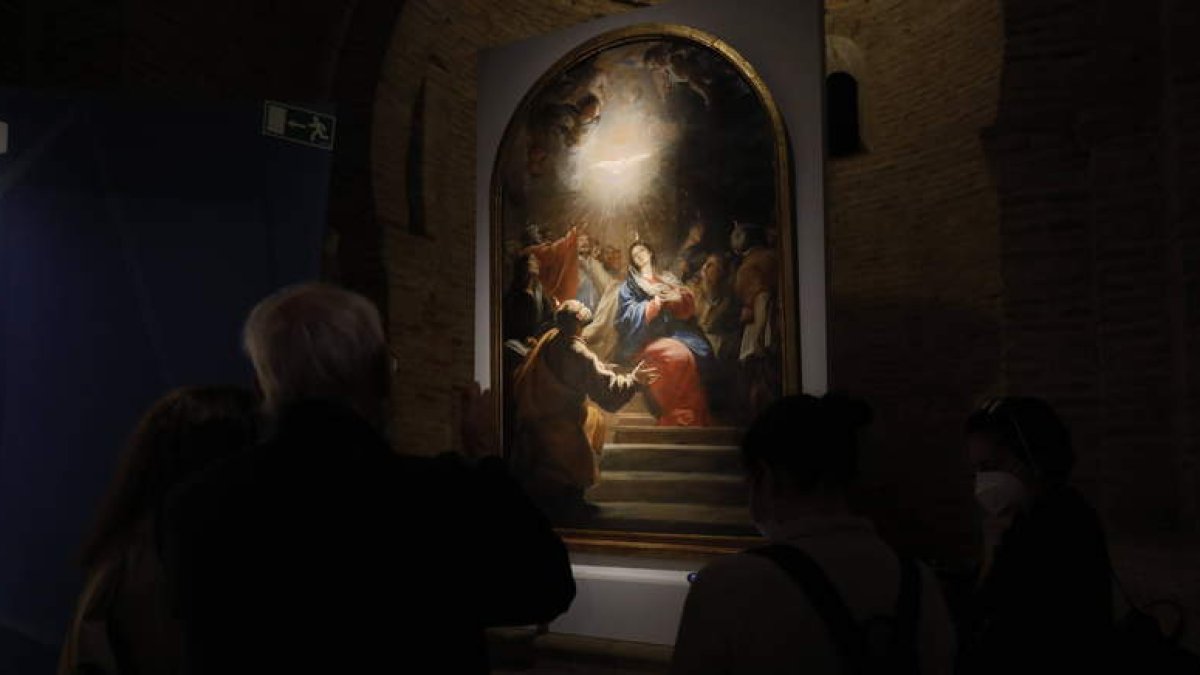 Varias personas contemplan una de las obras de la exposición ‘Lux’ en Sahagún. MARCIANO PÉREZ