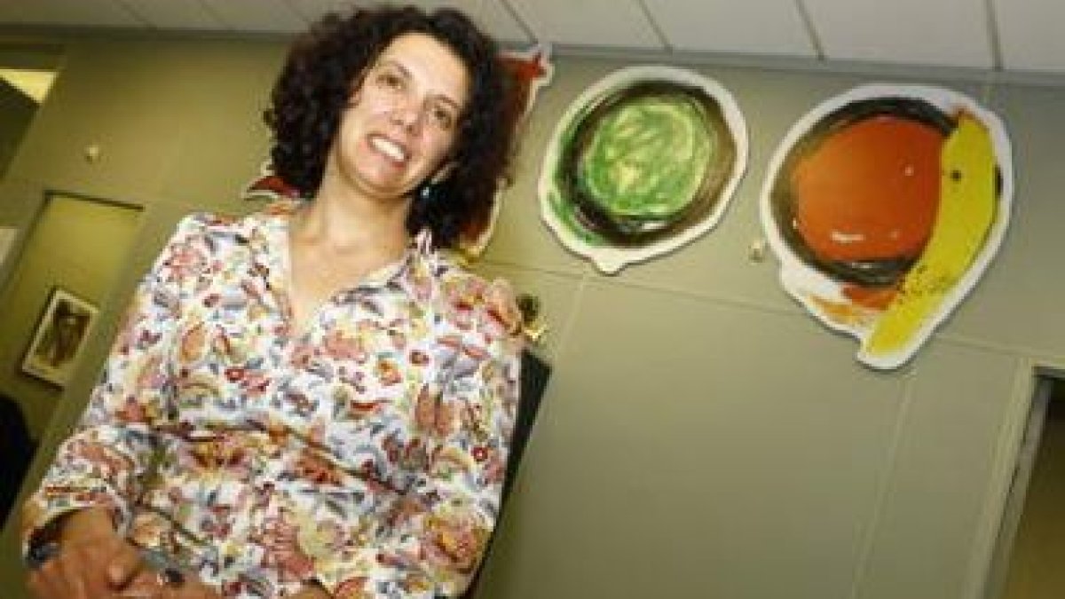 Ana Gaitero posa en las dependencias de Diario de León junto al logotipo del centenario del periódic
