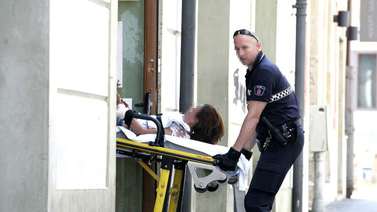 La Policía Local se lleva a la mujer herida.