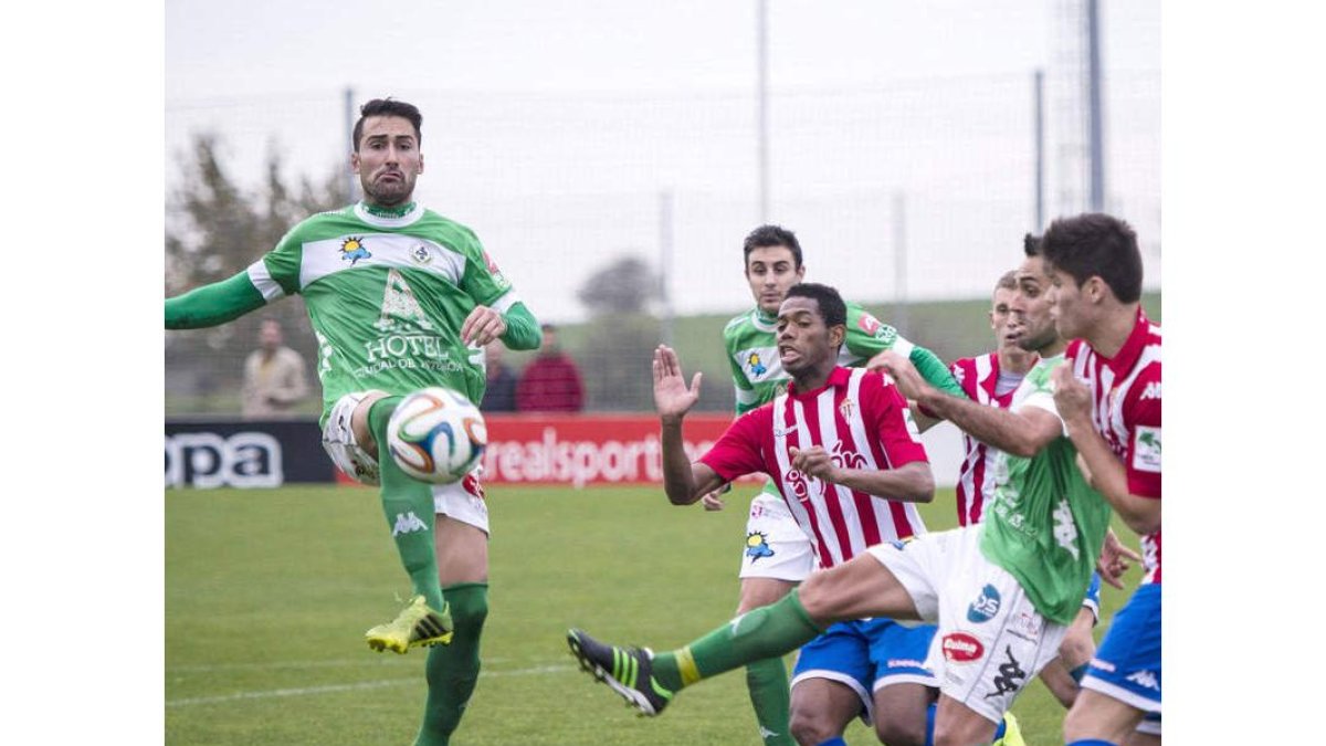 Víctor, a la izquierda, despeja un balón ante el acoso de los jugadores asturianos