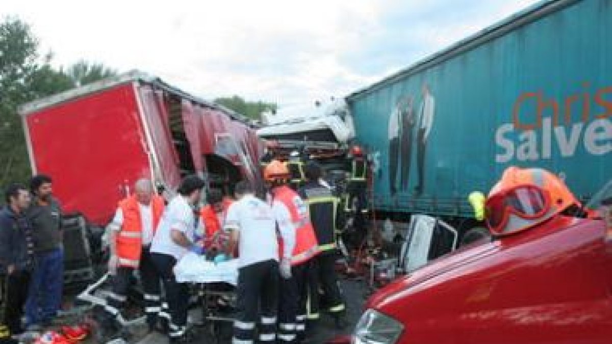 Momento en el que los bomberos y los médicos sacaron al camionero herido de la cabina.