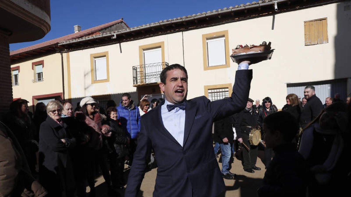 Distintas imágenes de la subasta de tartas en honor a San Antón a las puertas de la iglesia de Algadefe y fotografía de la escultura y fuente dedicada a la natalidad, ubicada en una de las plazas más céntricas del pueblo.