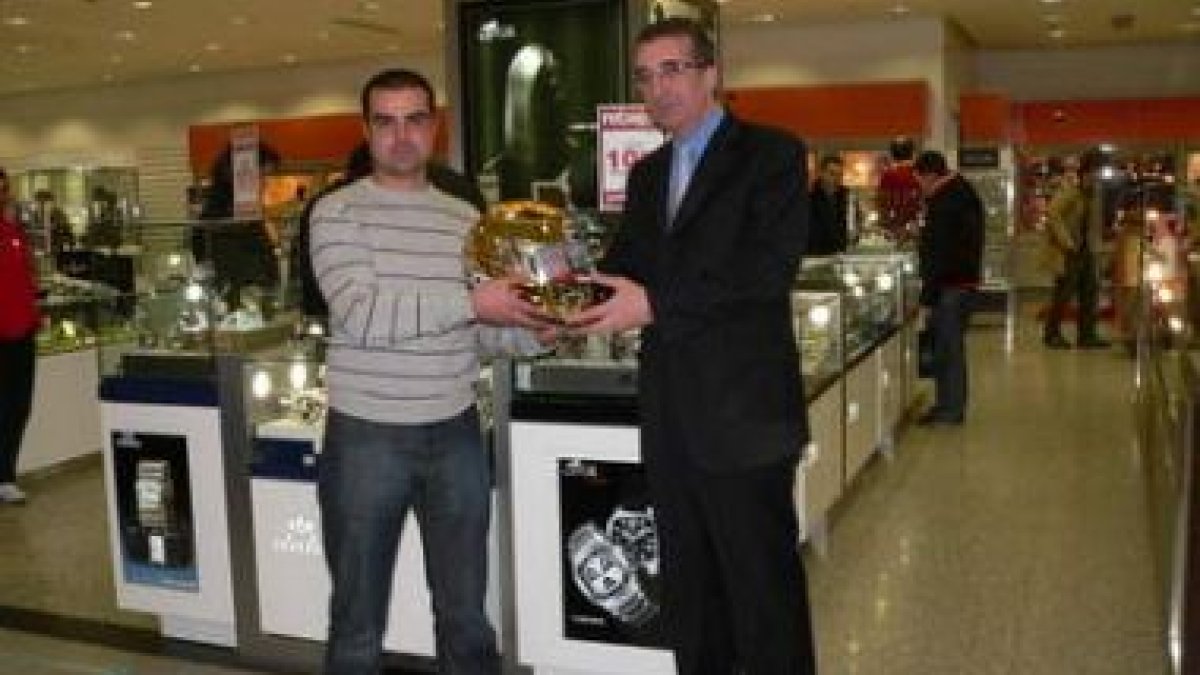 El gerente de la Planta Baja de El Corte Inglés, José Luis Benito, hace entrega del casco