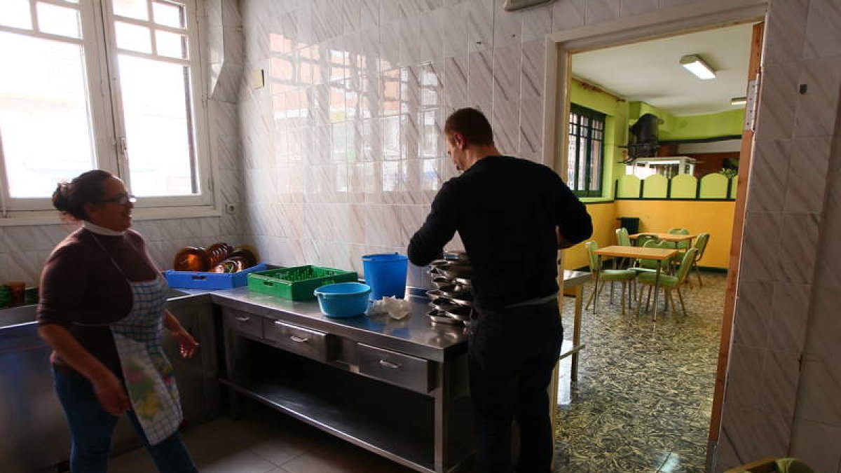 Dos voluntarios preparan la comida del comedor social.