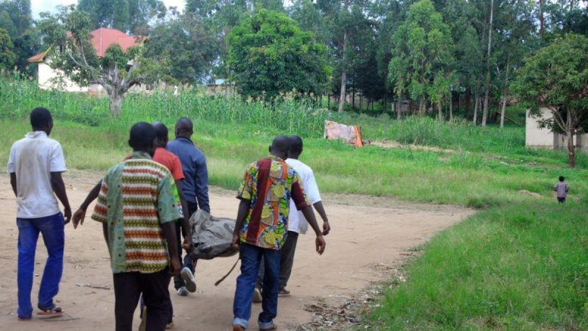 Residentes en una aldea del Congo trasladan el cadáver de una víctima de los choques del Ejército con el ADF.