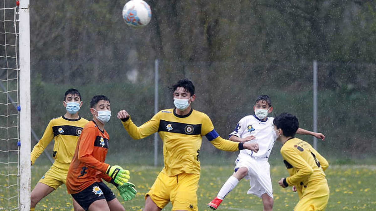 El partido de infantiles Villaquilambre-Peña B (3-2) fue muy vistoso y emocionante pese a la intensa llluvia. MARCIANO