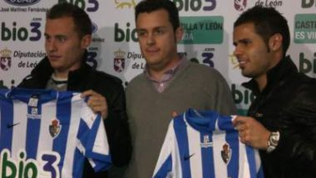 Los dos jugadores con sus nuevas camisetas en El Toralín junto al consejero delegado.