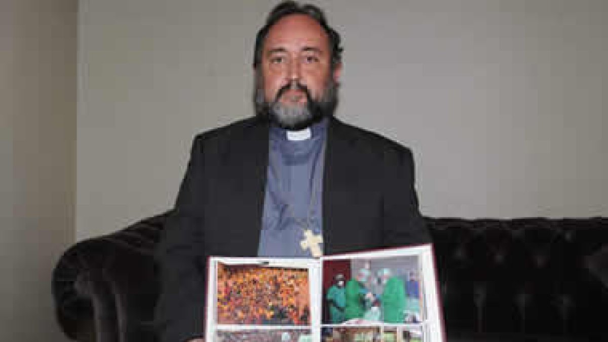 Juan José Aguirre posa con las fotos de las personas atendidas en su fundación.