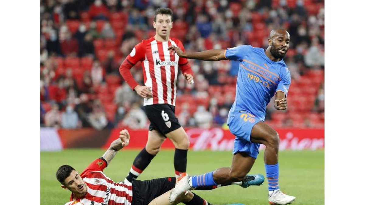 El defensa francés del Valencia Dimitri Foulquier pelea un balón con el zaguero del Athletic Yuri Berchiche. LUIS TEJIDO