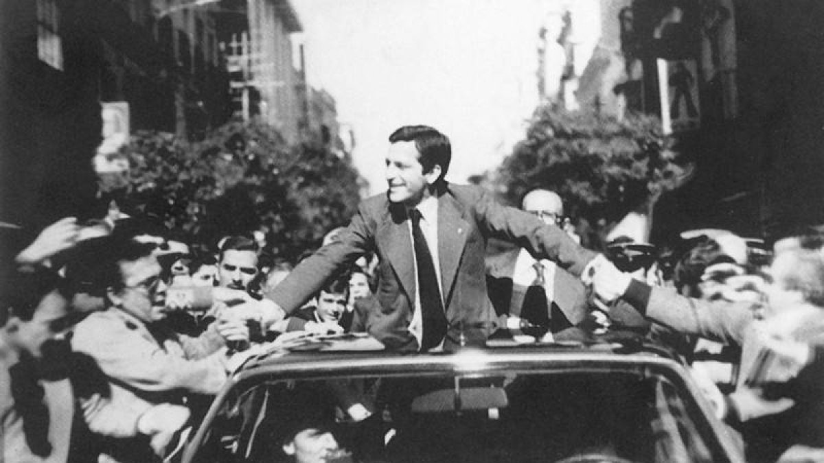 Adolfo Suárez saluda desde su coche durante una campaña