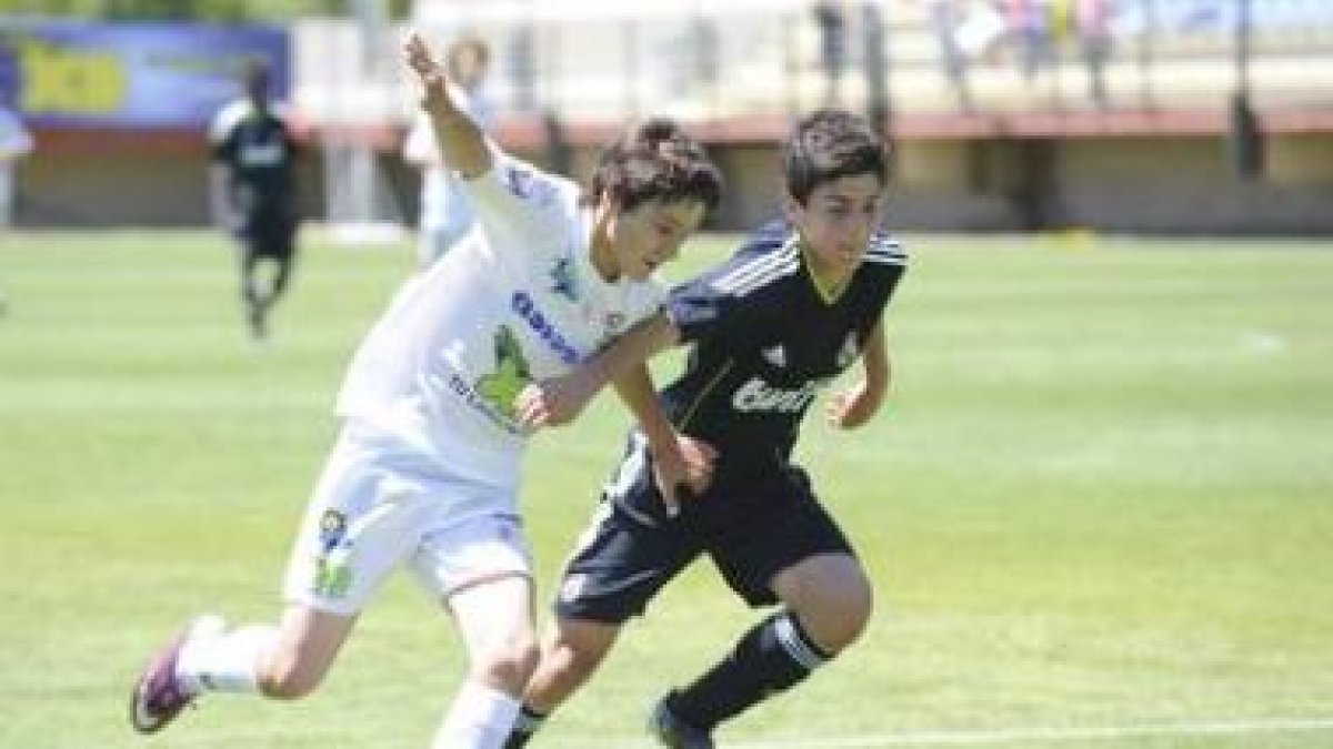 Ángel (i) pugna por el balón con el madridista Cedenilla.