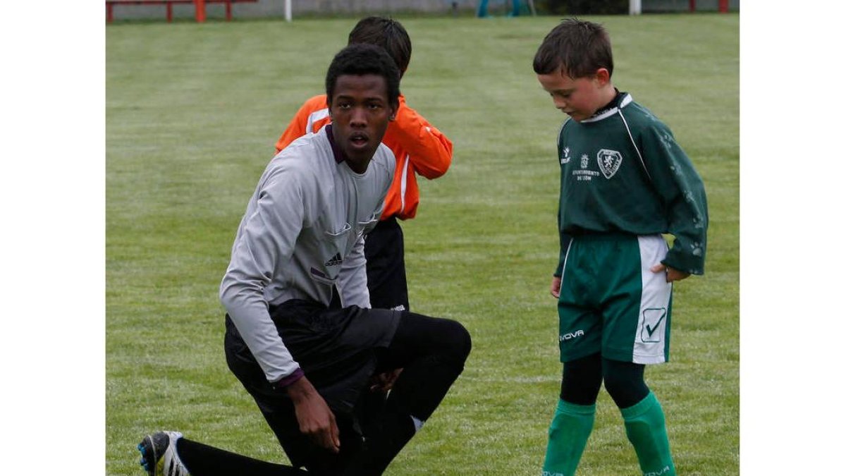 Mesaud ata los cordones de la bota de un jugador del Atlético Pinilla prebenjamín.