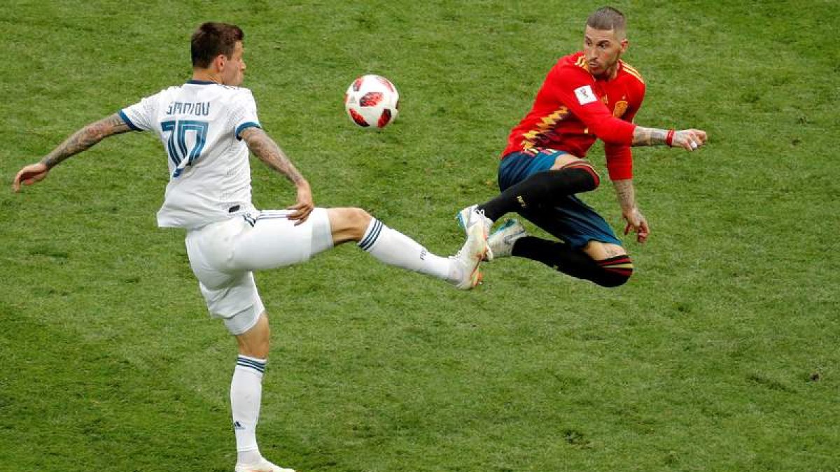 El capitán de la selección Sergio Ramos lucha por el balón con el delantero ruso Smolov durante el partido de octavos de final ante la anfitriona, que eliminó a La Roja. LAVANDEIRA JR