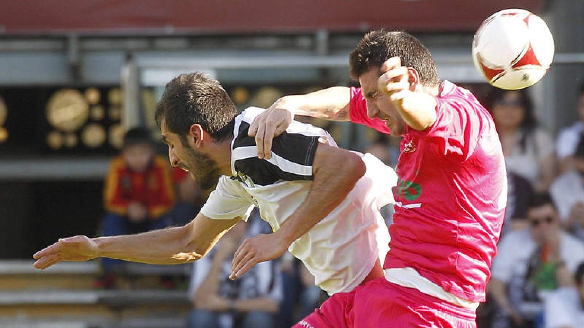 El defensa leonés Alberto Negral, a la derecha, trata de imponerse a su par durante el transcurso del derbi entre el Burgos y la Cultural en el estadio de El Plantío.