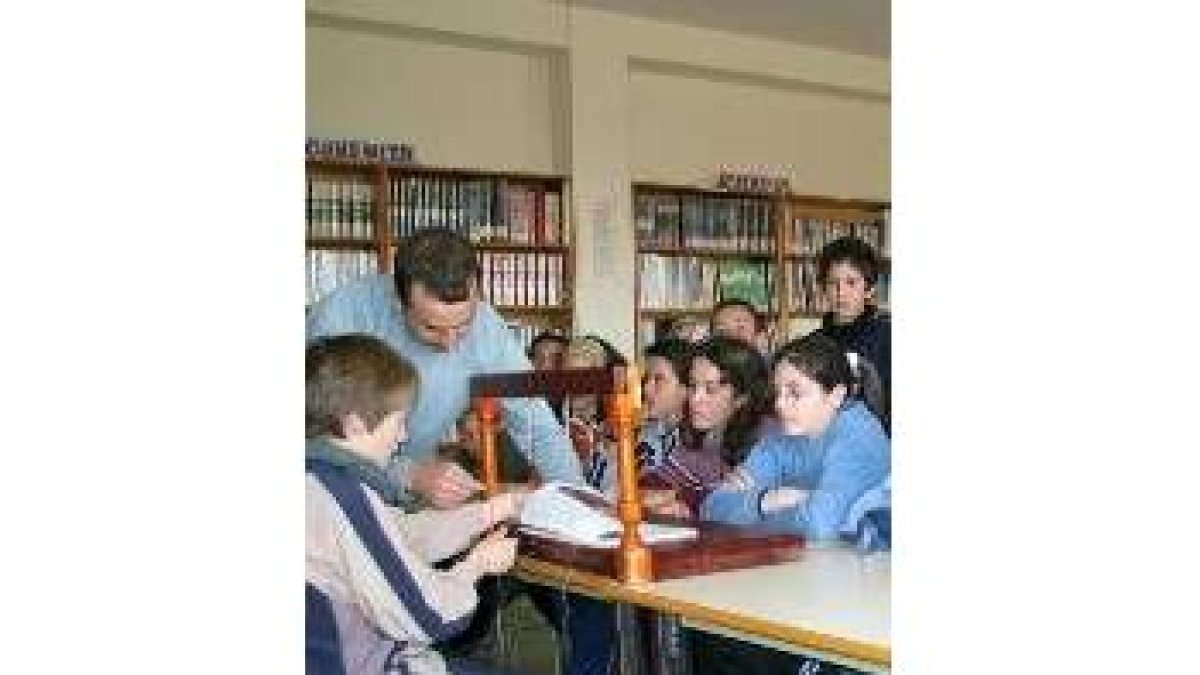 Un profesor explica a varios alumnos cómo encuadernar un libro