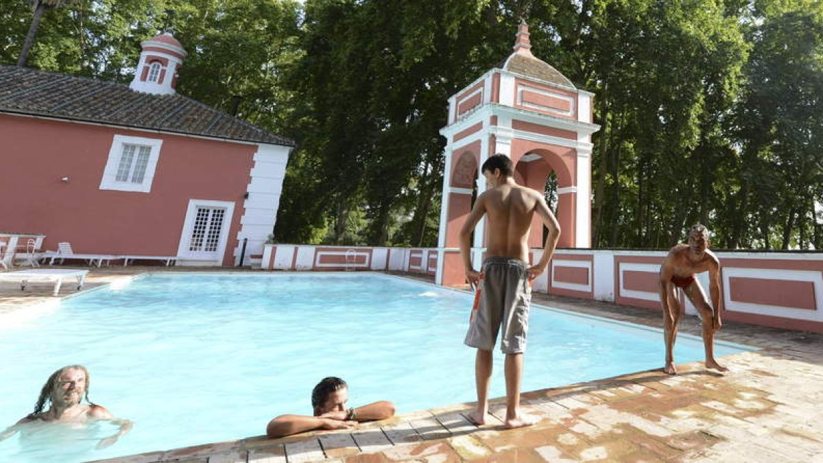 Jornaleros se bañan en la piscina del Palacio de Moratalla, tras ser ocupada la zona ajardinada.