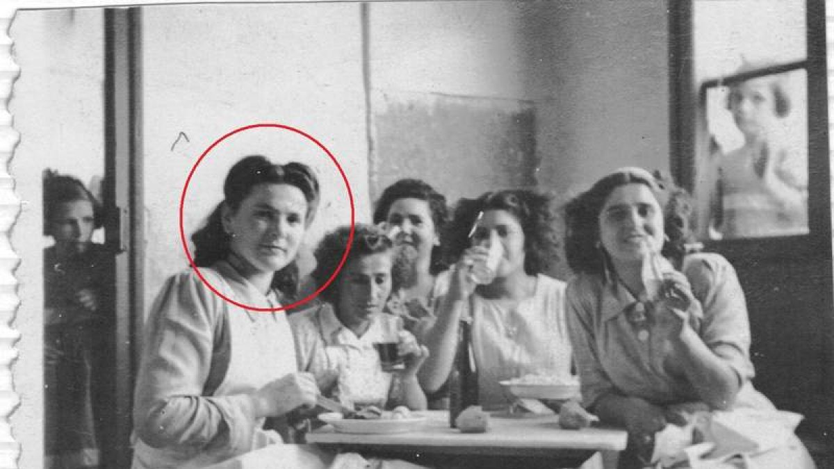 Antonia, con el círculo rojo, tomando un piscolabis con compañeras del hospicio. Las pequeñas las contemplan desde la ventana