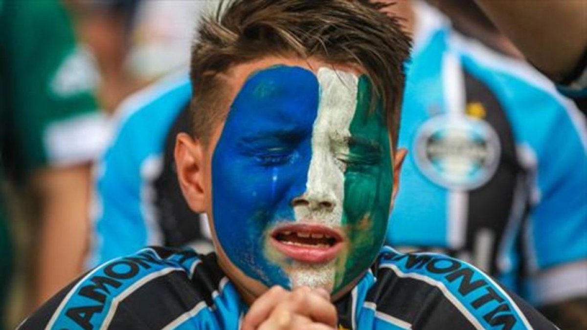 Un aficionado del Gremio llora durante el homenaje al Chapecoense.