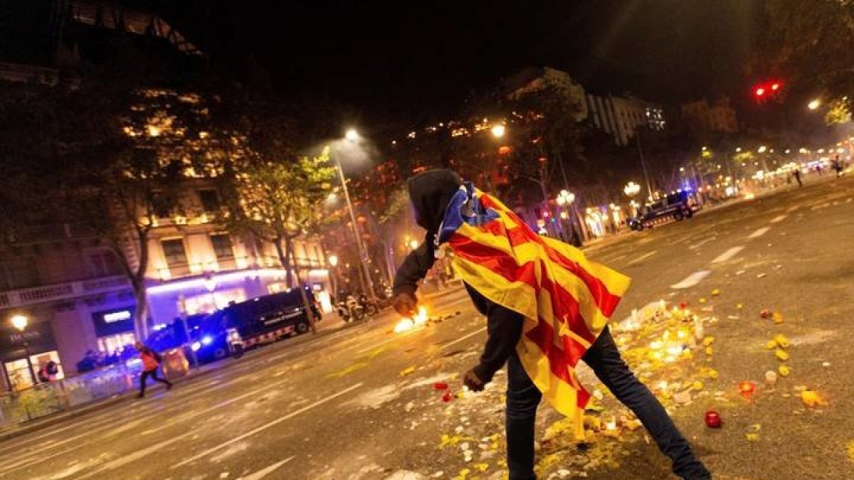 Un manifestante se enfrenta a los Mossos de Escuadra junto a la Delegación del Gobierno en Barcelona. ENRIC FONTCUBERTA