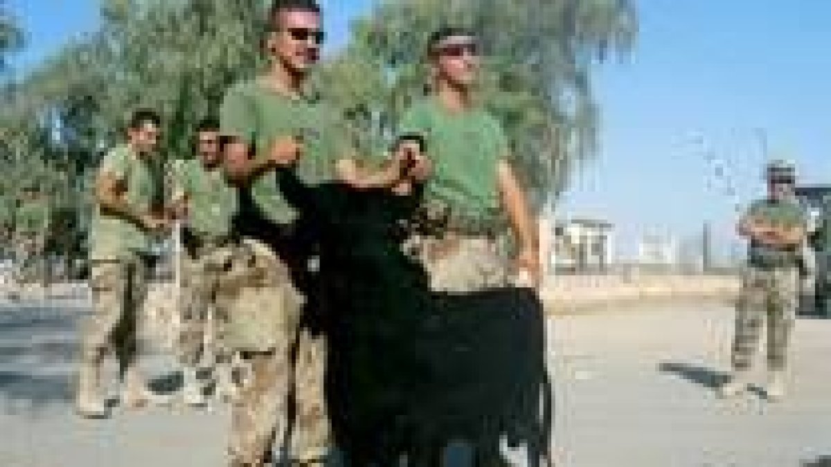 Varios miembros de las tropas españolas desplazadas a Irak sujetan la efigie del toro