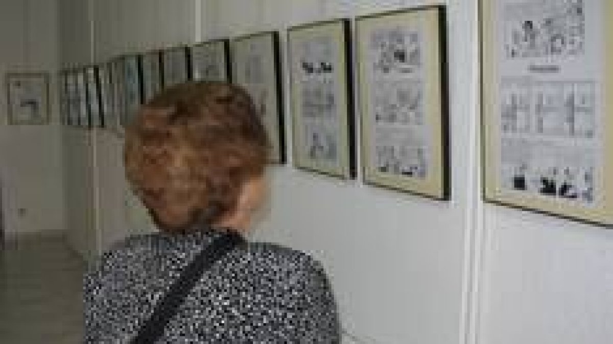 Una mujer contempla algunas de las tiras de periódico expuestas en la Semana del Cómic