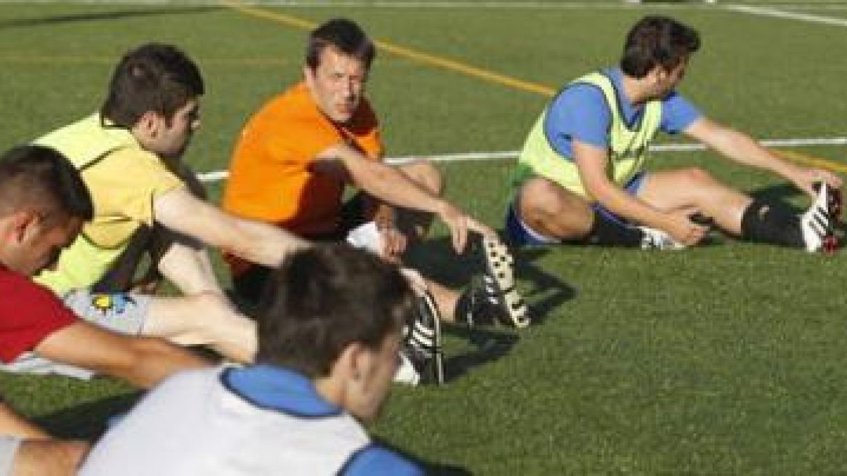 Carlos Valiño estira junto con algunos de sus jugadores en la vuelta a los entrenamientos.