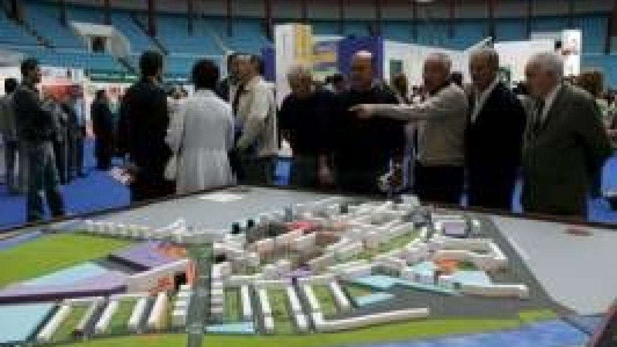 Varios visitantes contemplan una de las maquetas que se exponen en la Feria Inmobiliaria de León