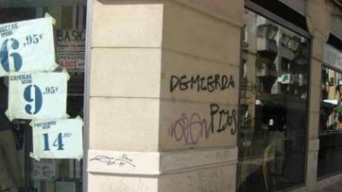 Aspecto de una de las múltiples fachadas ensuciadas en la ciudad con pintadas.