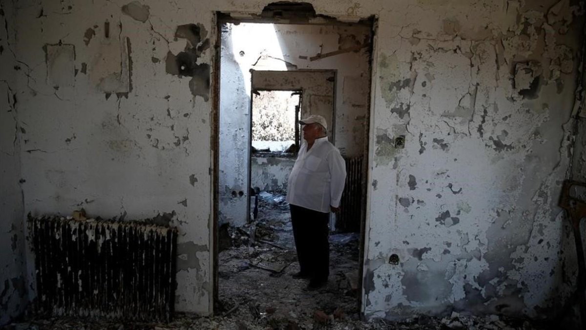 Un hombre en su casa quemada de Mati. /