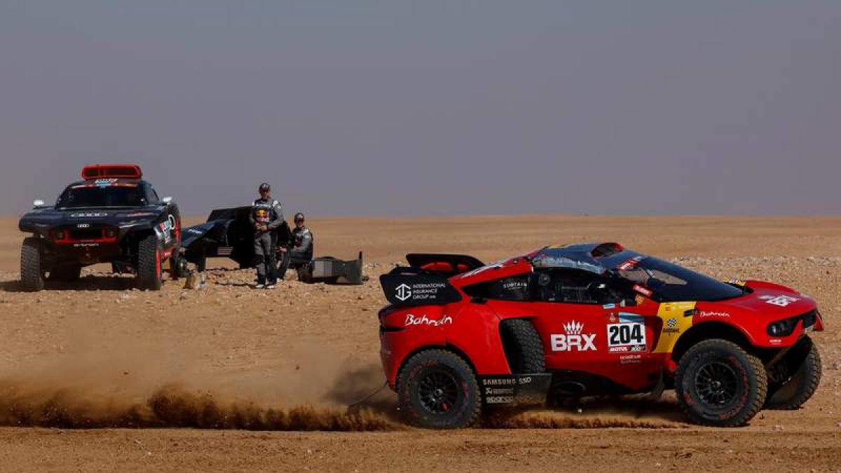 Nani Roma, que sufrió un accidente en la jornada, pasa por delante del coche de Peterhansel. BIEL ALIÑO