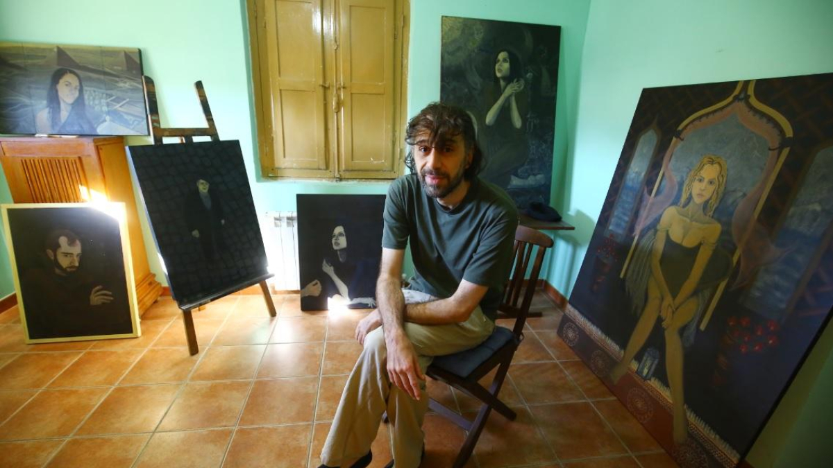 Alain Yebra, escritor y pintor afincado en el Bierzo, junto a varias de sus obras en su casa de Toral de los Vados (León)