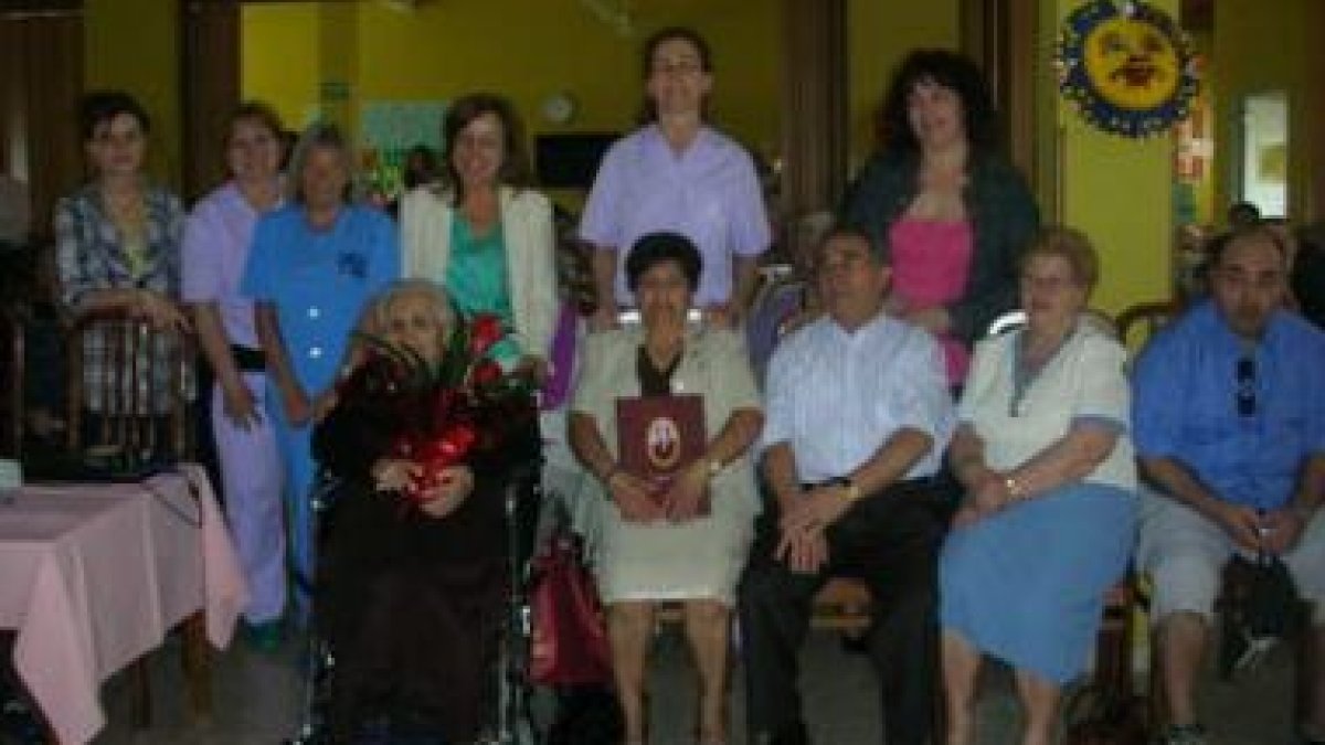 Zósima García, rodeada de familiares y cuidadoras, sostiene las flores que recibió.
